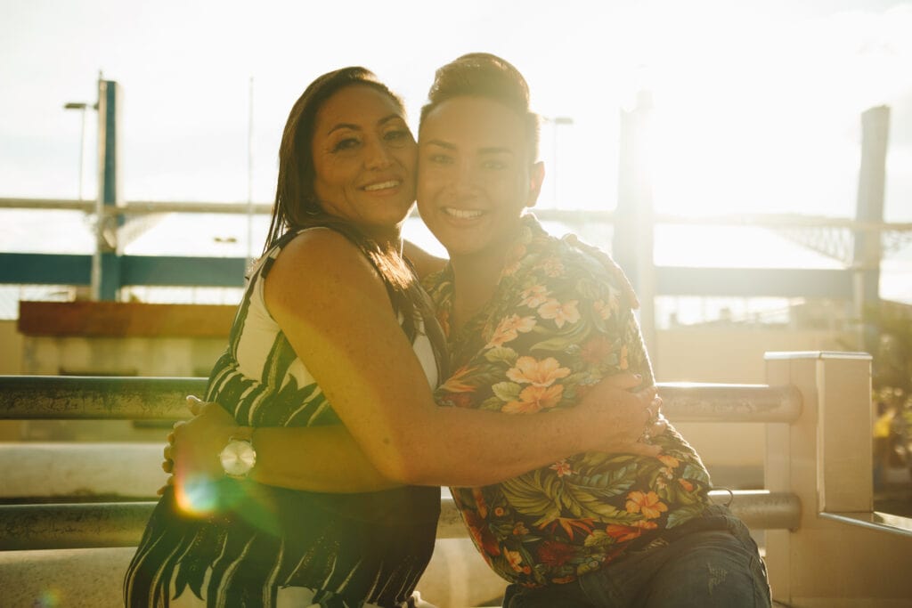 Madre E Hijo Gay Abrazándose En Frente A La Luz Del Sol