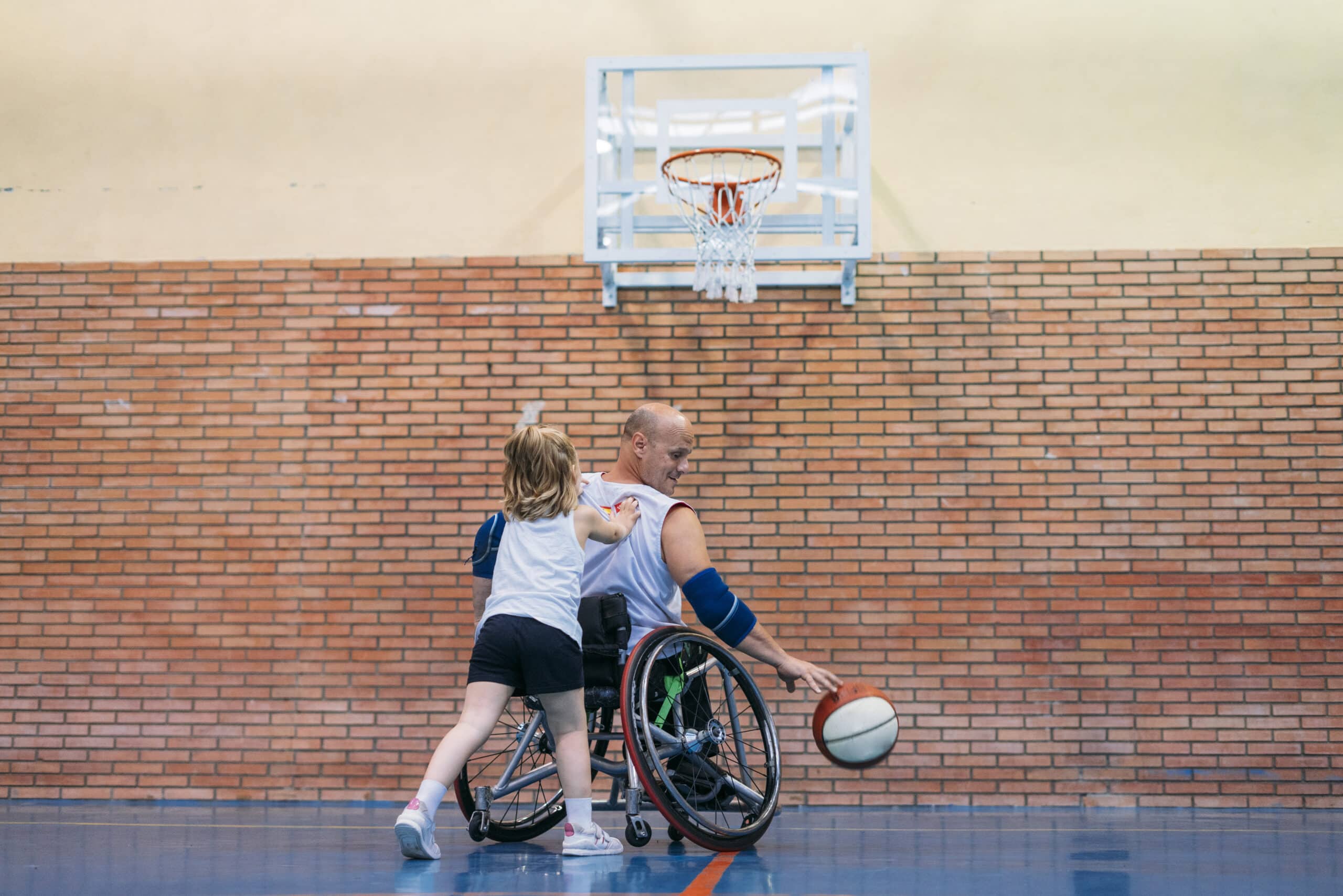 Disabled Sport Men And Little Girl In Action While Playing Indoor Basketball