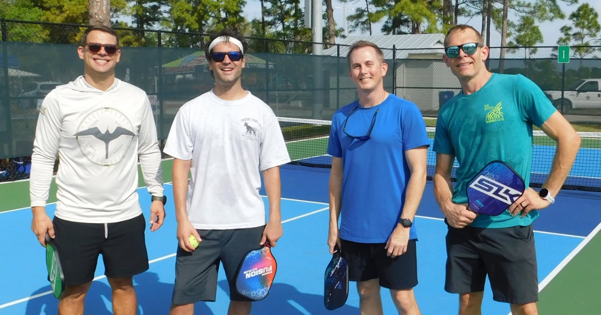 Four Male Pickle Ball Playes On Court